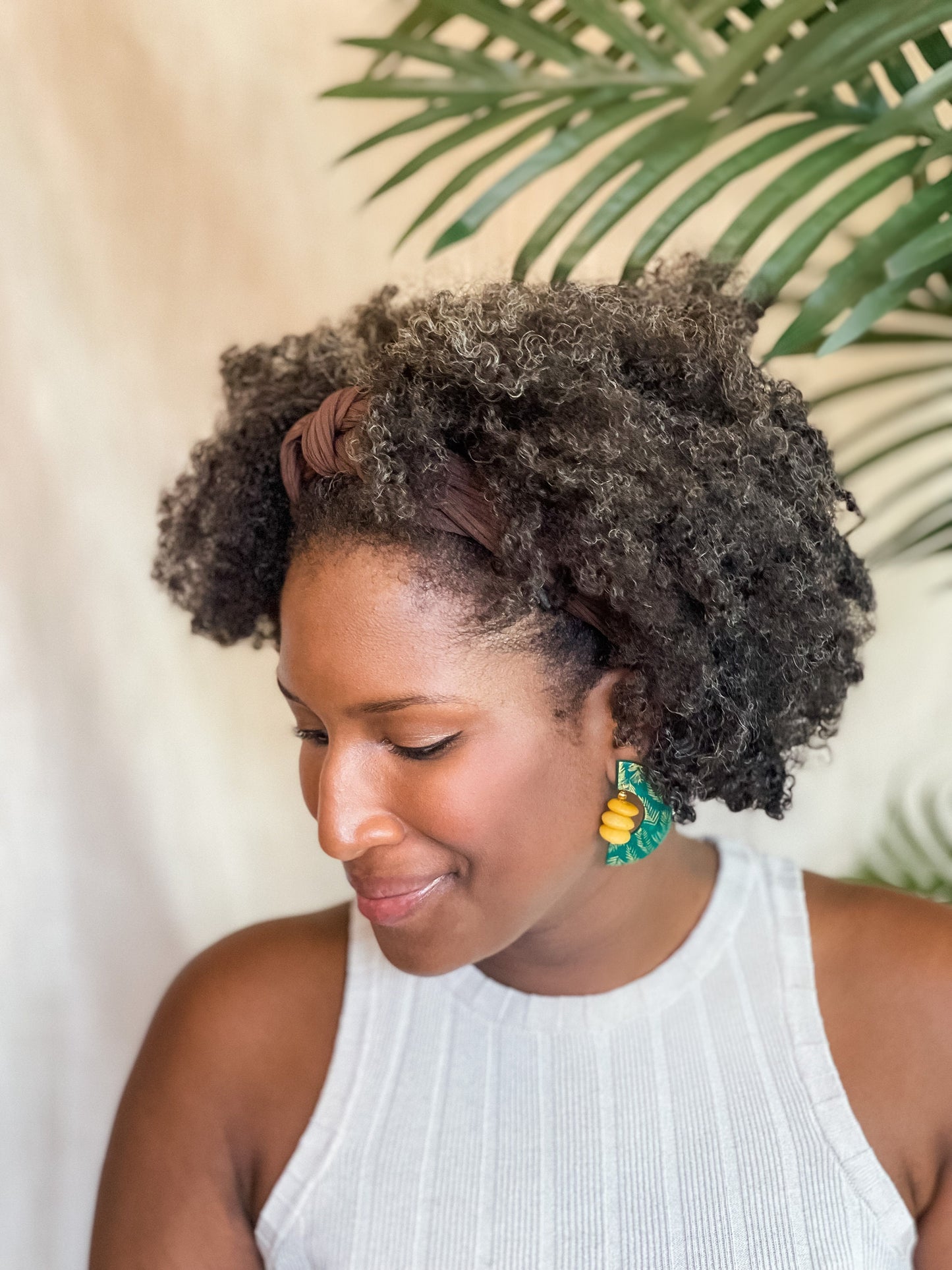 Woman wearing green African-Inspired earrings with recycled glass beads Atiwo Designs