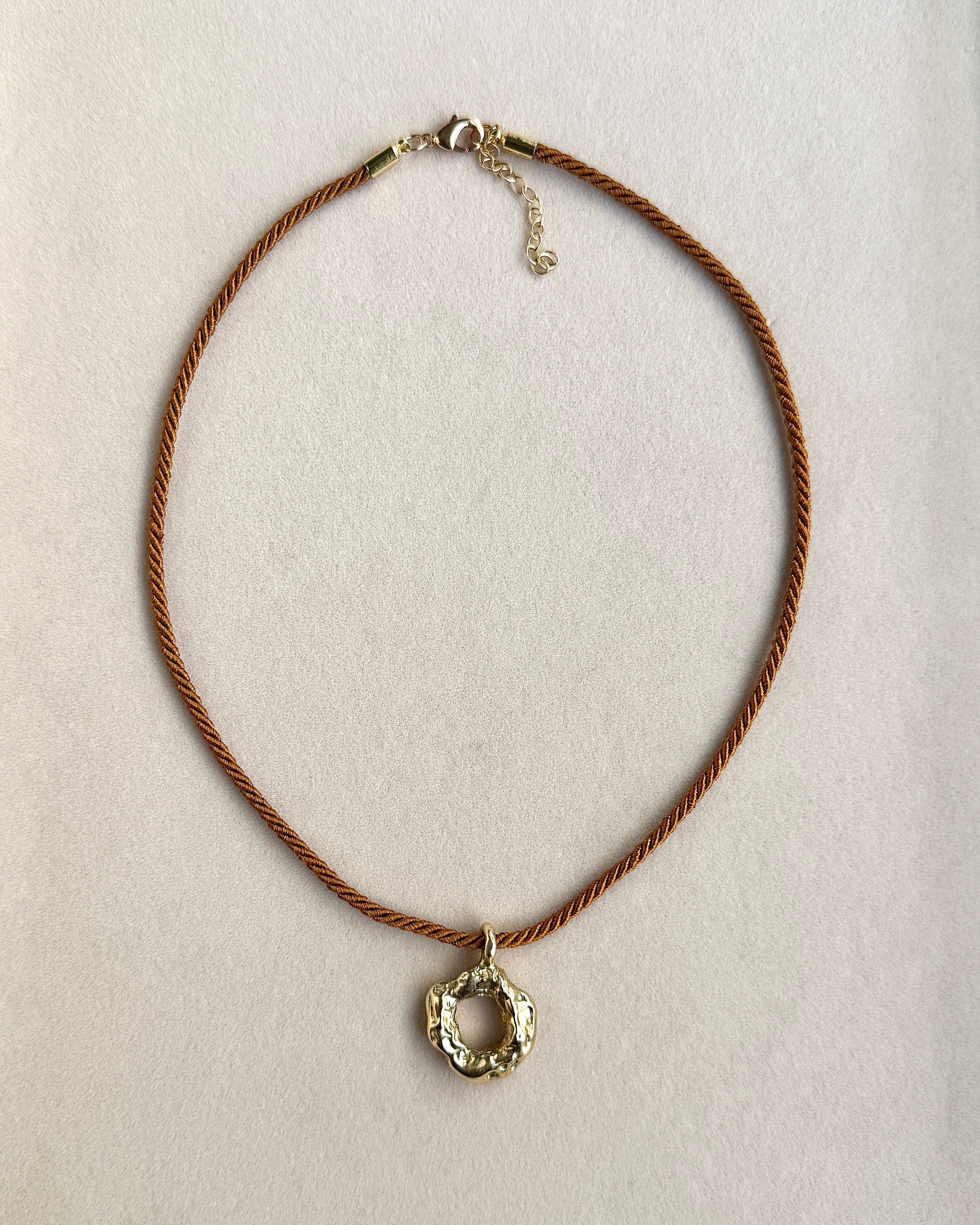 Necklace with a circular pendant on a white card