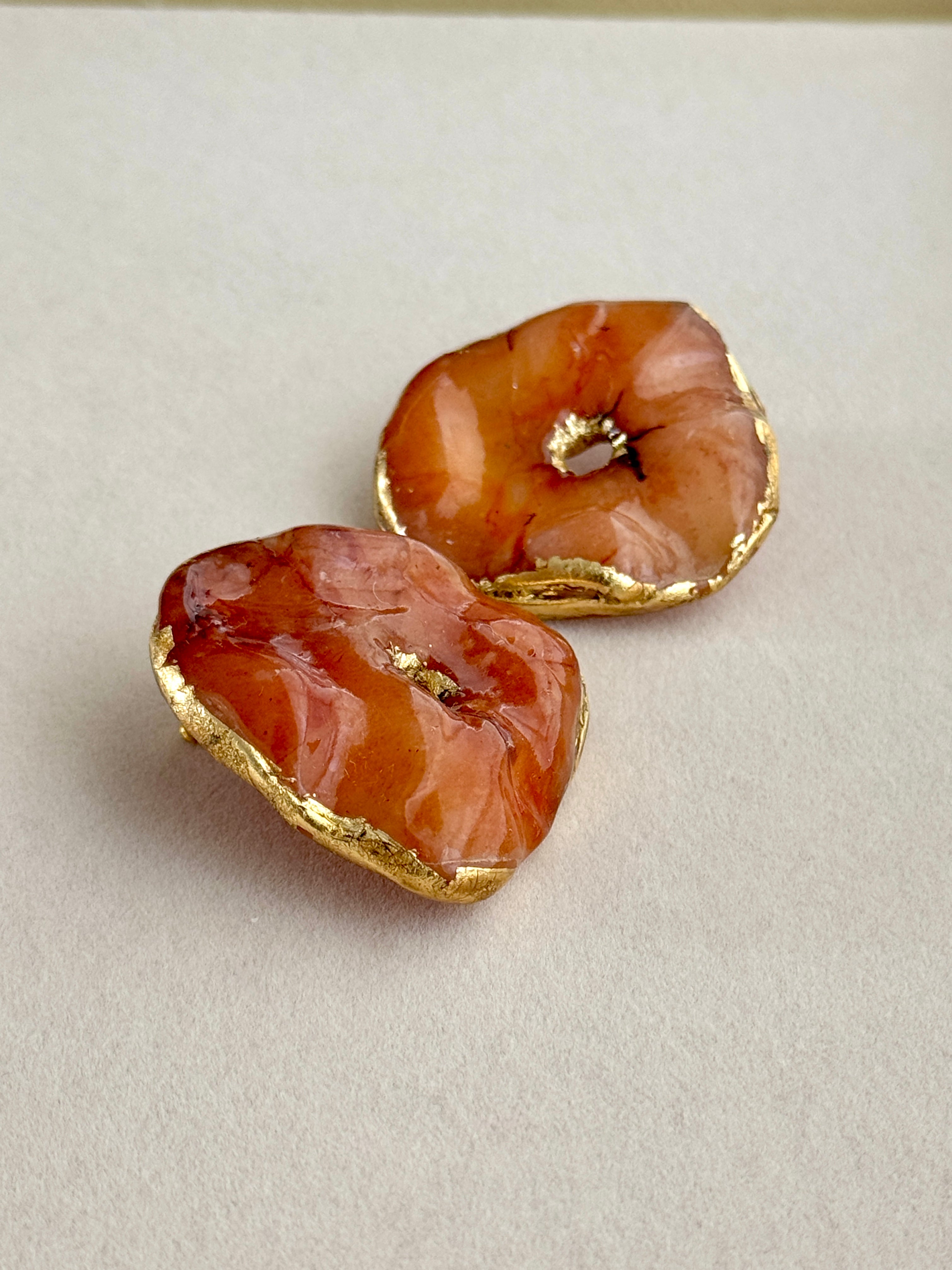 Heart-shaped earrings with gold accents on a light gray background