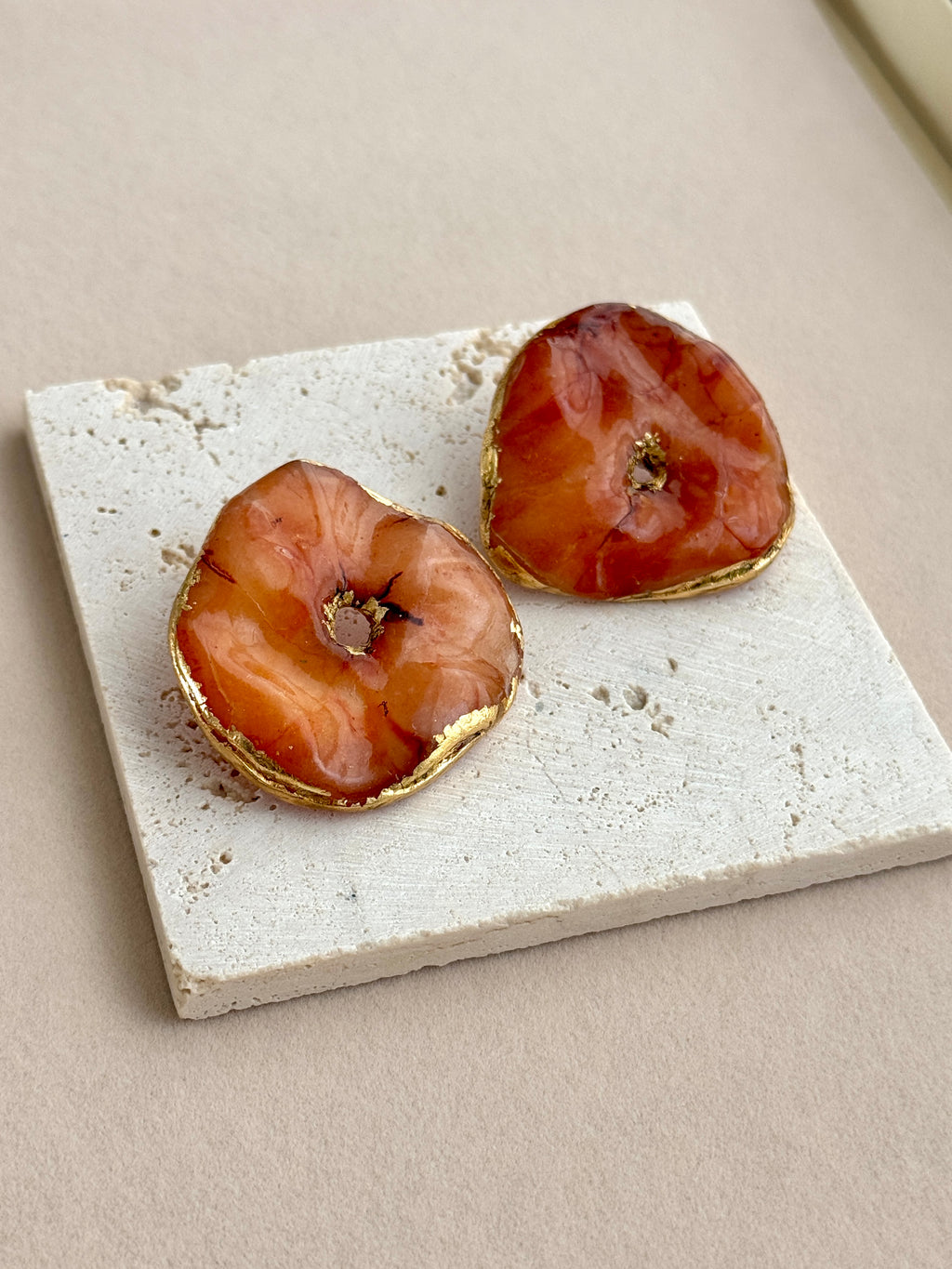 Pair of earrings on a textured stone surface