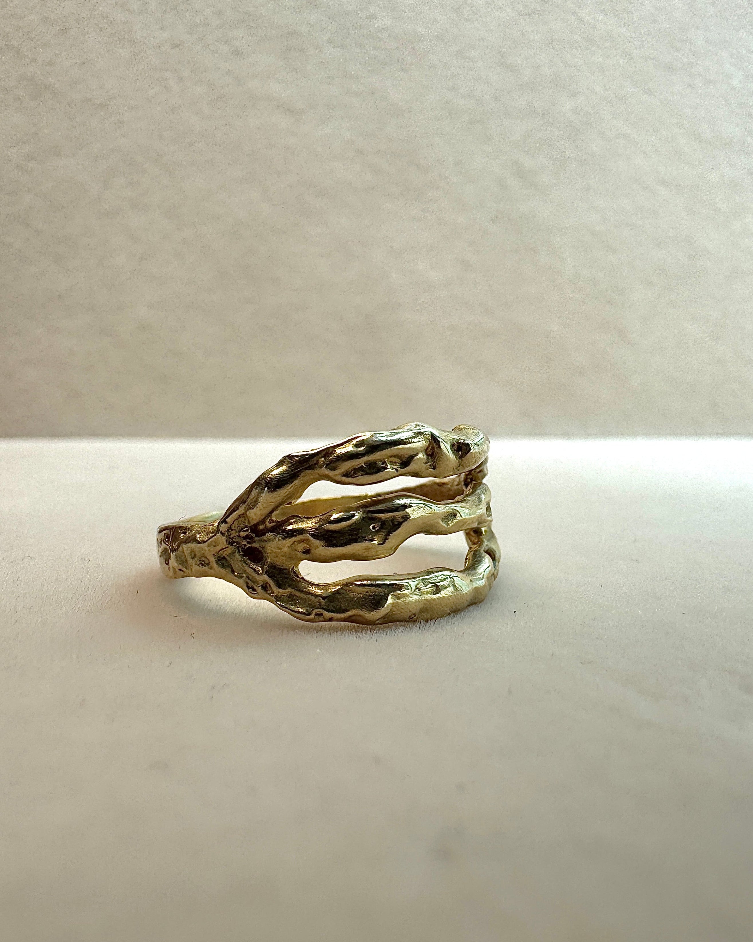Brass ring with a unique design on a light gray background