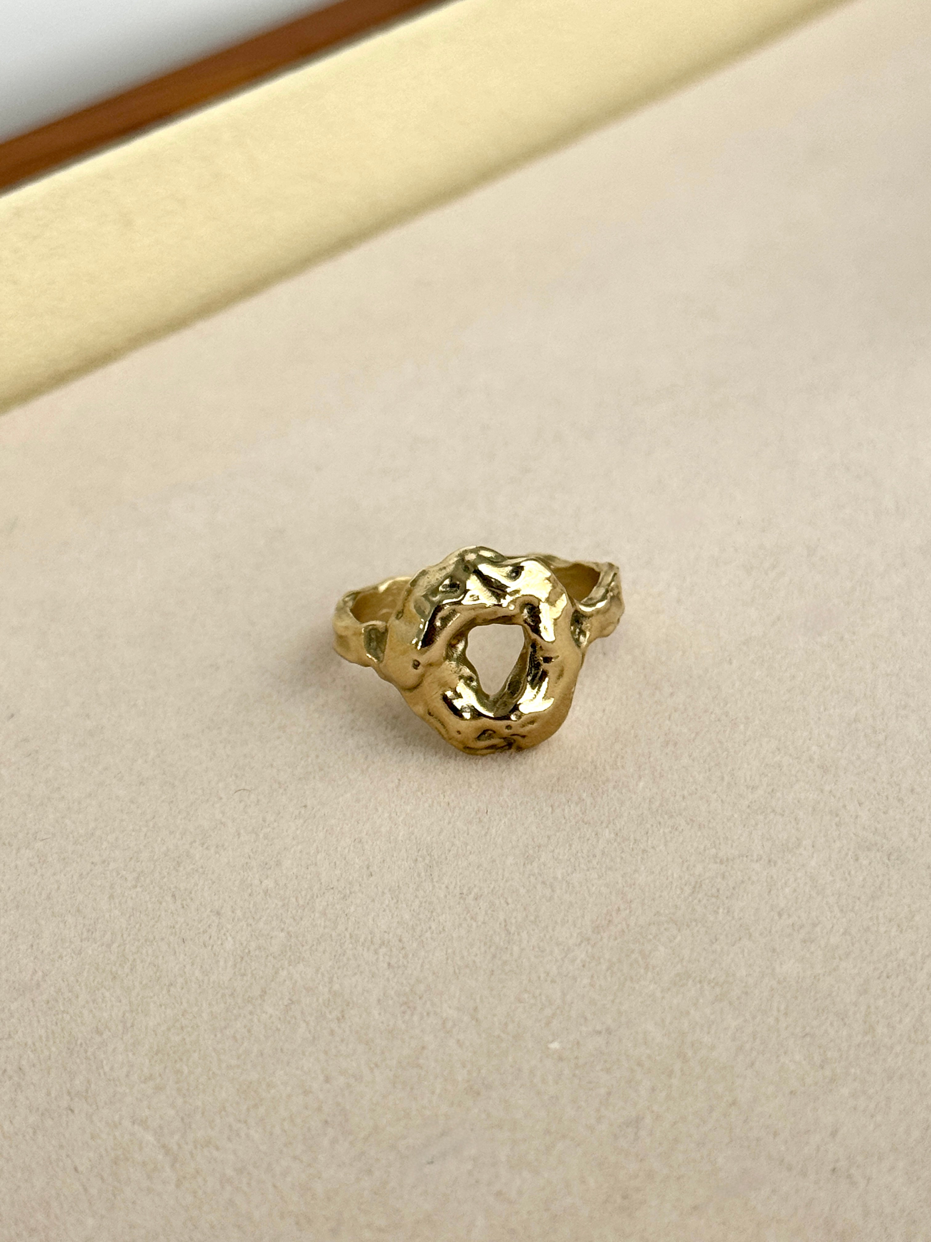 Gold ring on a beige cushion