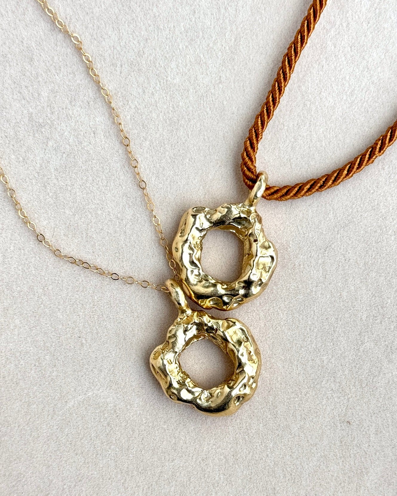 Gold pendant necklace on a light gray background