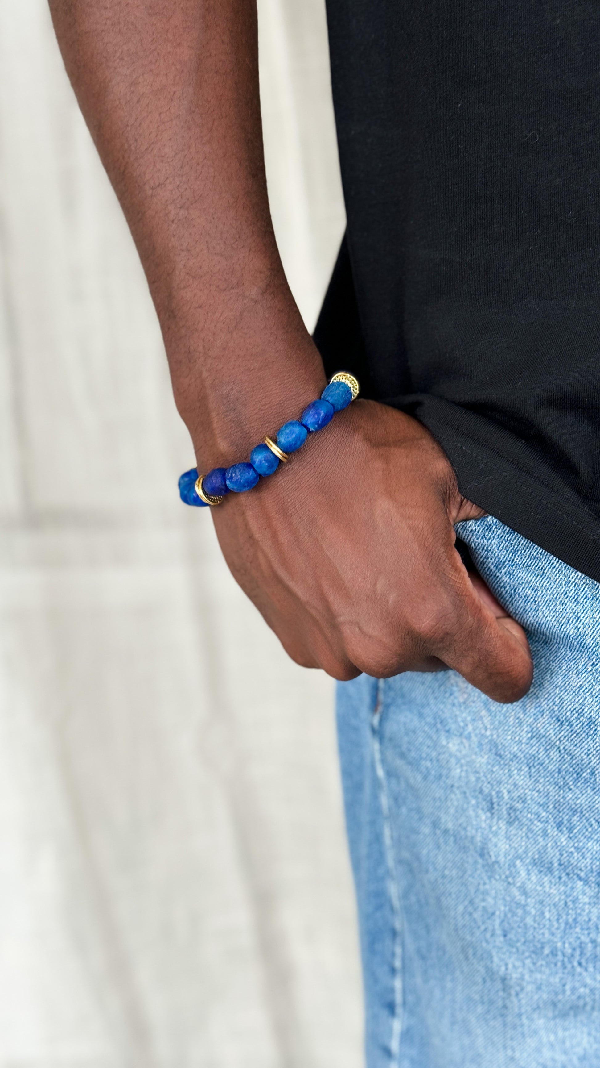 Arm of a man wearing African beads bracelets