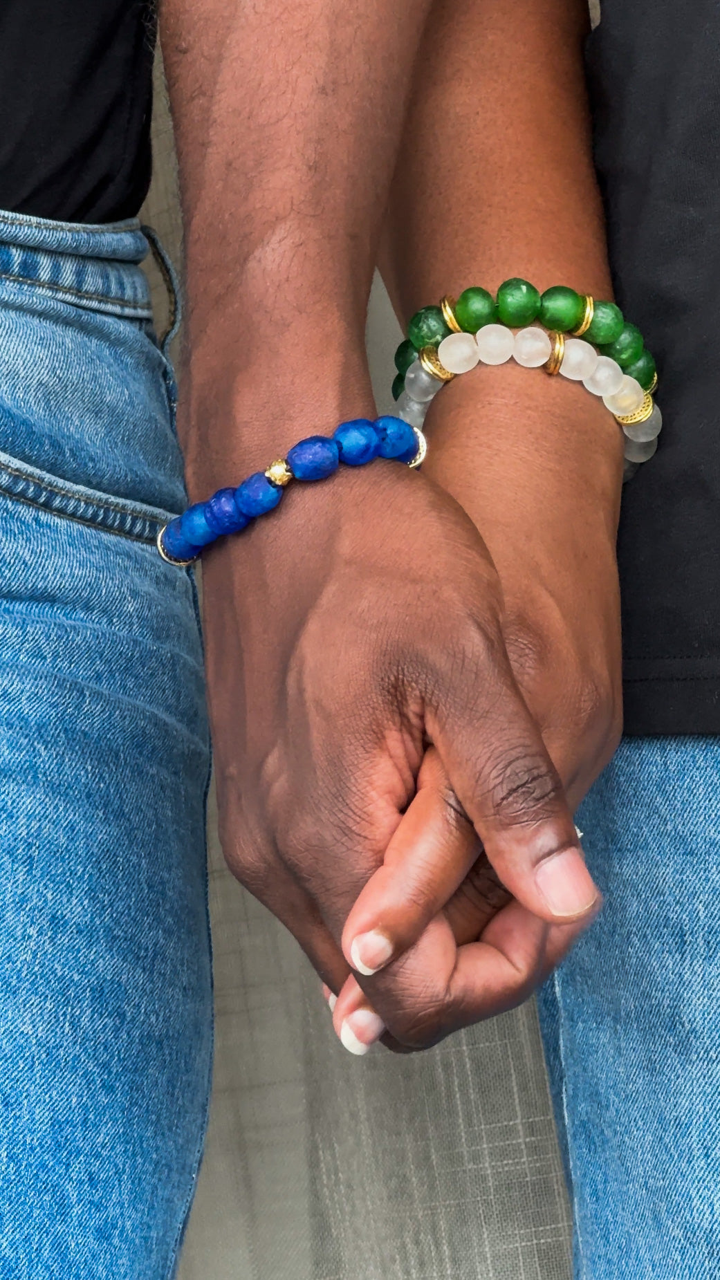 Man and Woman holding hands and wearing African beads bracelets