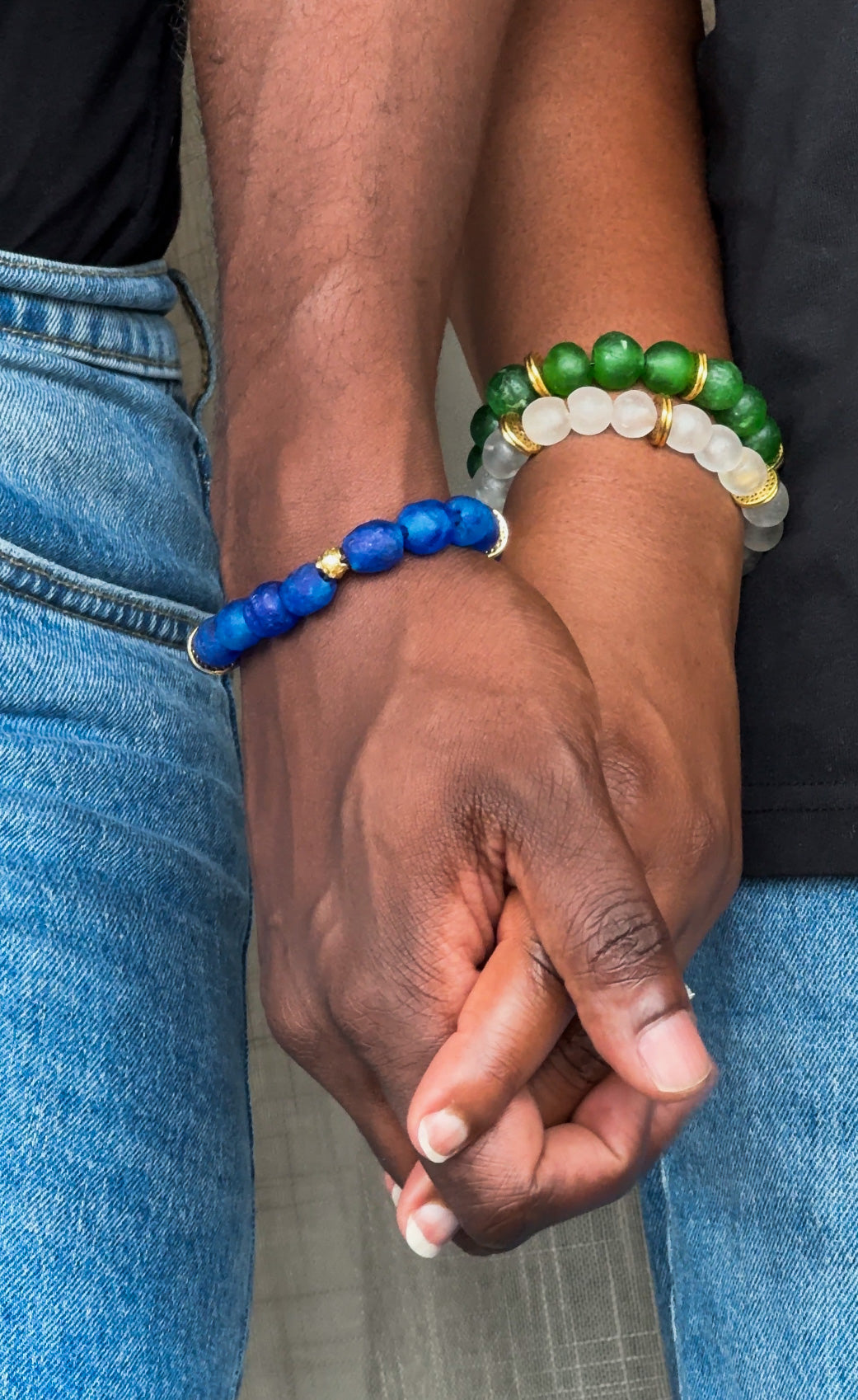 Man and Woman holding hands and wearing African beads bracelets