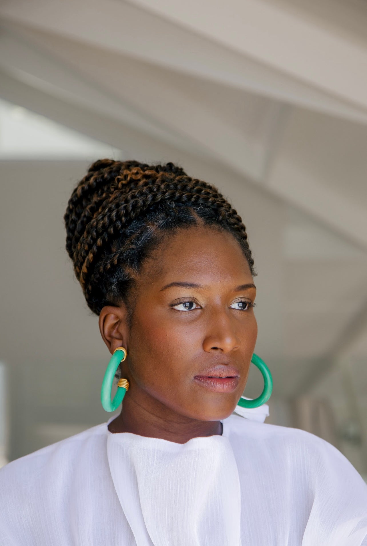 Woman wearing Jade-inspired hoop earrings with gold details Atiwo Designs