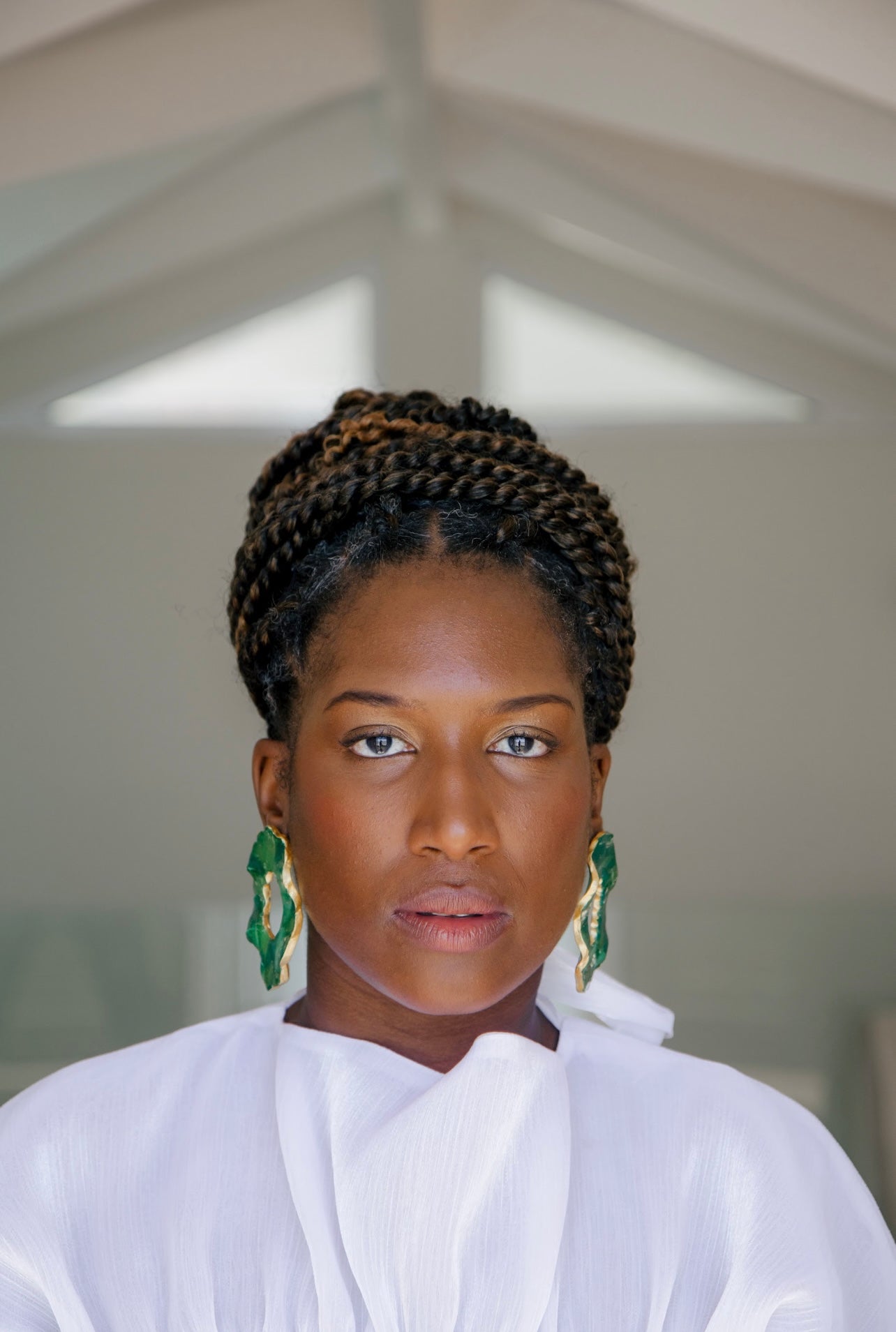 Woman wearing Jadeite earrings with gold trim Atiwo Designs